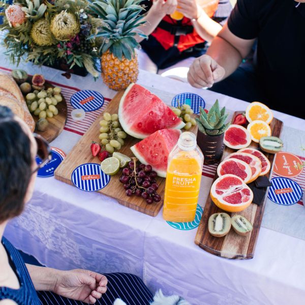 a group of people sitting at a table with a cake