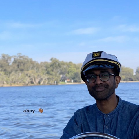 a man standing next to a body of water