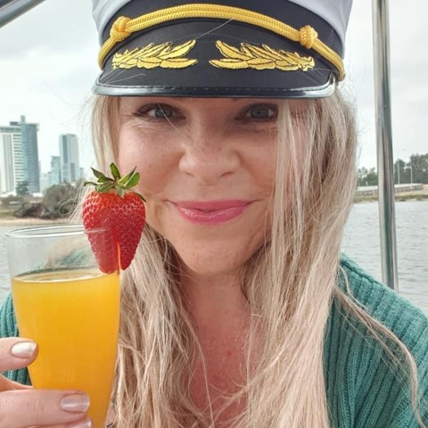 a woman wearing a hat and sunglasses posing for the camera