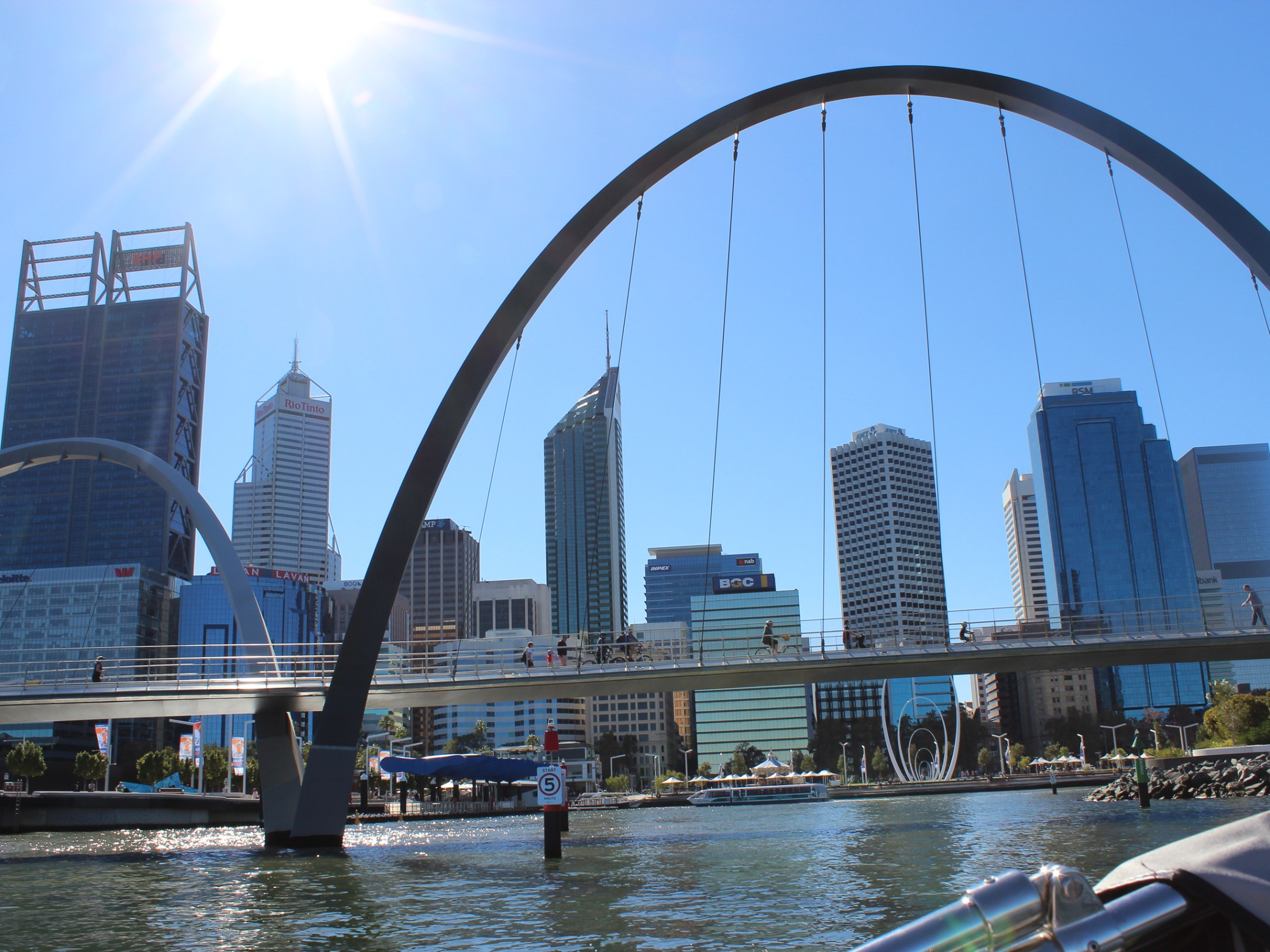 a bridge over a body of water with a city in the background