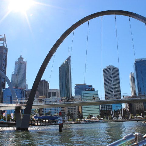a bridge over a body of water with a city in the background