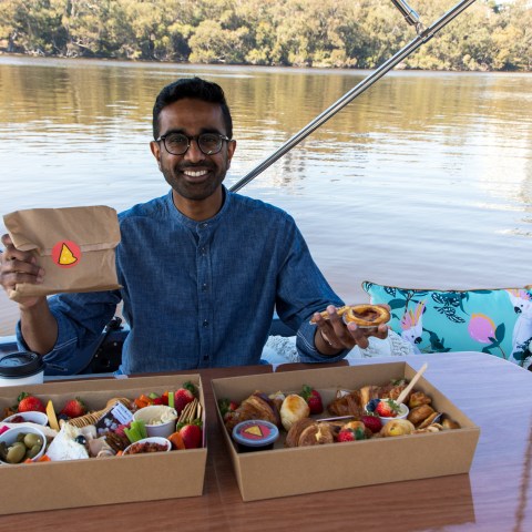 a man sitting at a table in front of a body of water