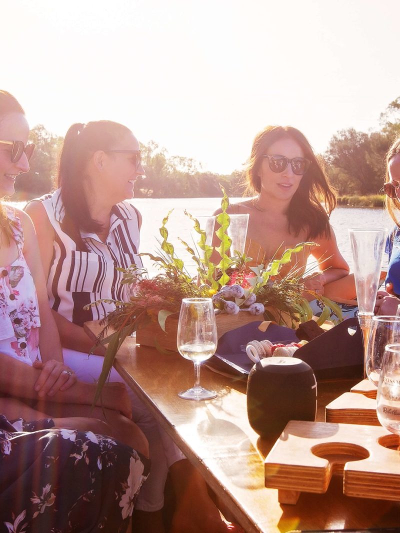women sitting at a table in the boat with wine glasses