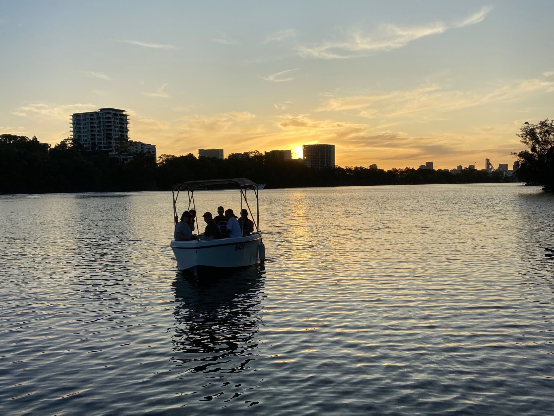 a boat floating along a river next to a body of water