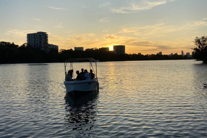 a boat floating along a river next to a body of water