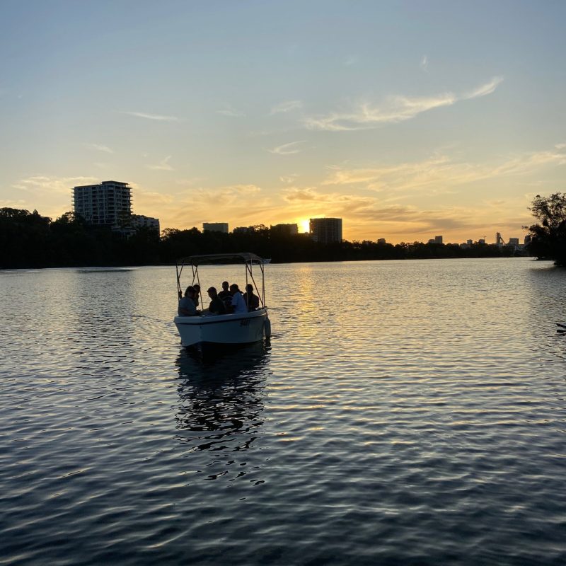 a boat floating along a river next to a body of water