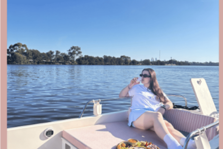 a woman sitting at a table in front of a body of water